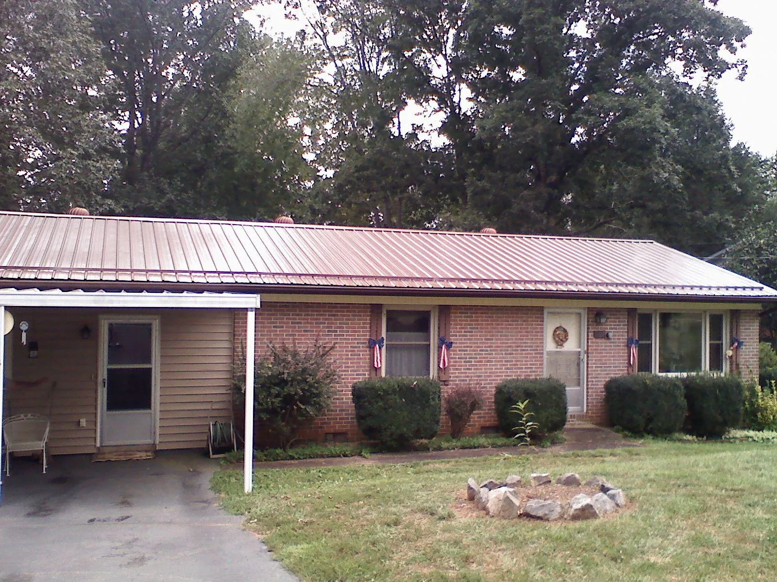 Bronze metal roof and carport on a brick ranch home — Roof Repair work by our crew in New Bedford